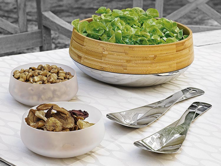 Miska na salát, oříšky a houby na prostřeném stolu