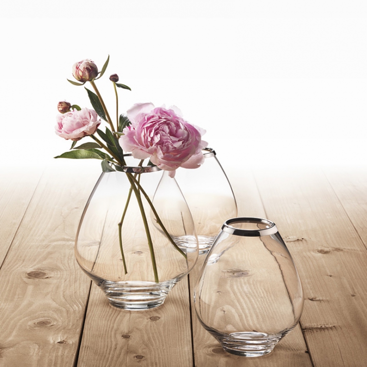 Skleněné vázy na dřevěné podlaze s květinami