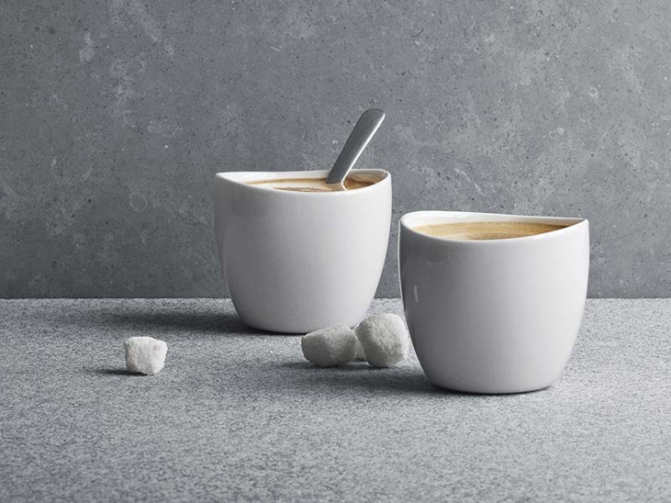 Dva šálky kávy s kostkami cukru na stole