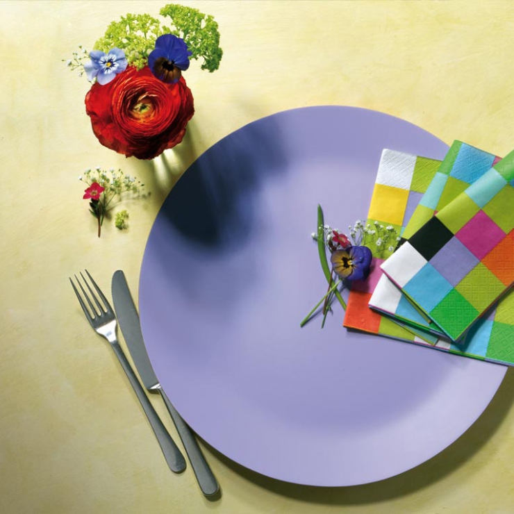 Fialový dřevěný talíř s barevnými ubrousky a květinovou dekorací