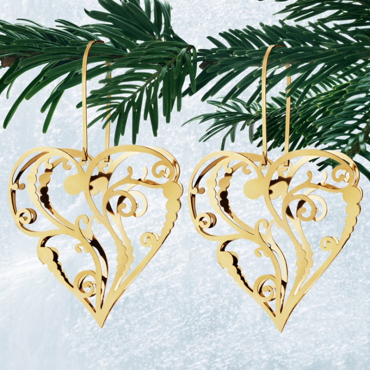 Pozlácené vánoční ozdoby ve tvaru srdce na visíci na větvičce stromu